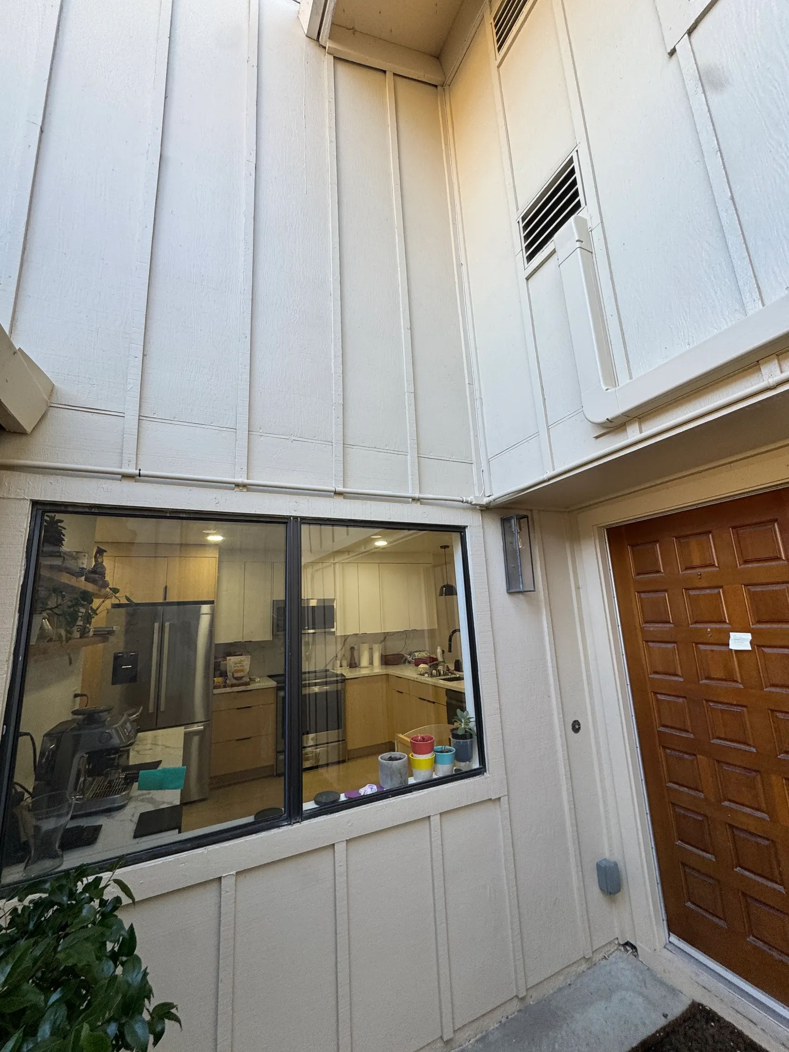 Service vehicle and tools visible behind the front entry of a West Los Angeles mechanical workshop with a residential supply register above the door